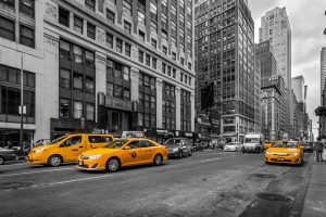 New York yellow taxis in a black and white scene