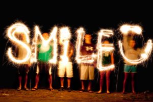 A group of people waving sparklers in the air to paint with light in a photograph